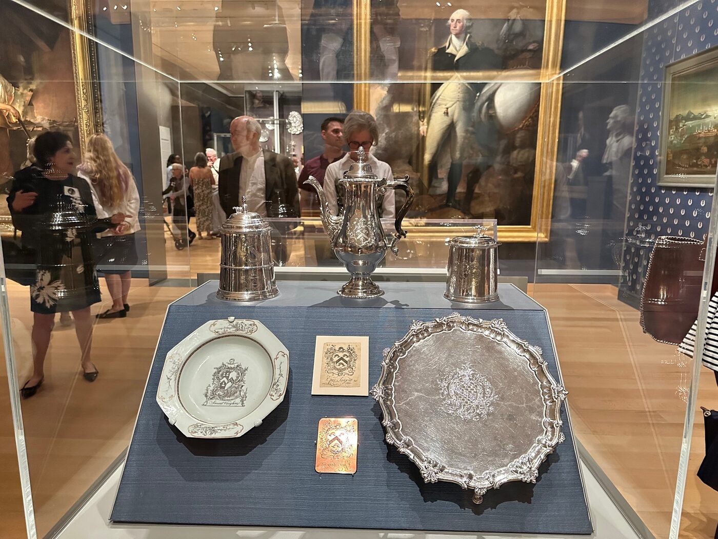 A glass case of early American silver platters and decorative objects at the MFA, Boston.