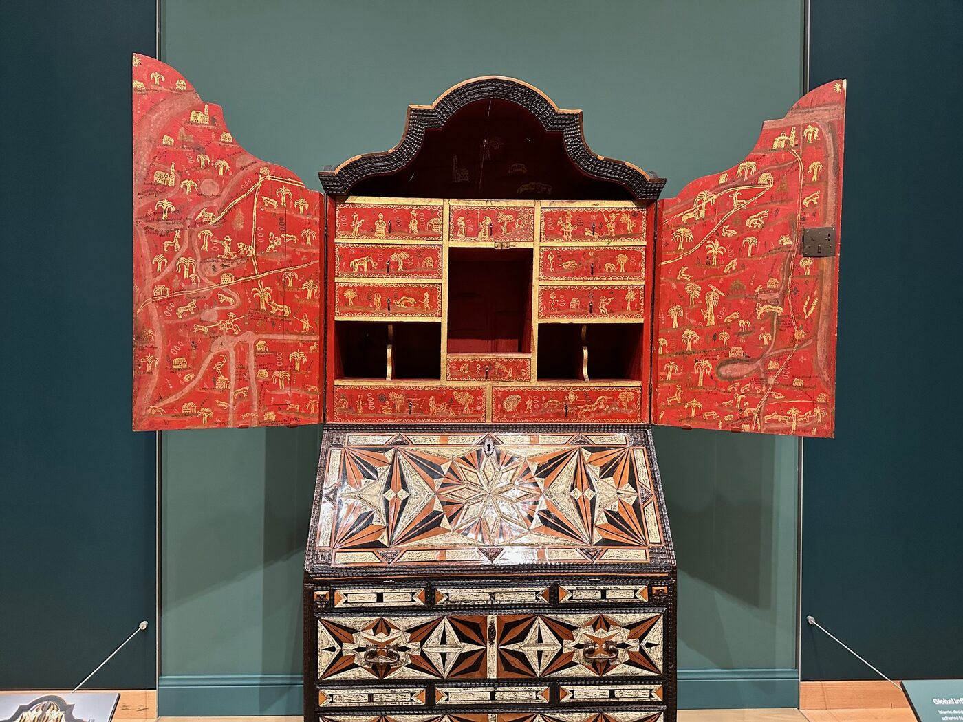 A brightly painted, patterned American cabinet in the galleries at the Museum of Fine Arts, Boston.
