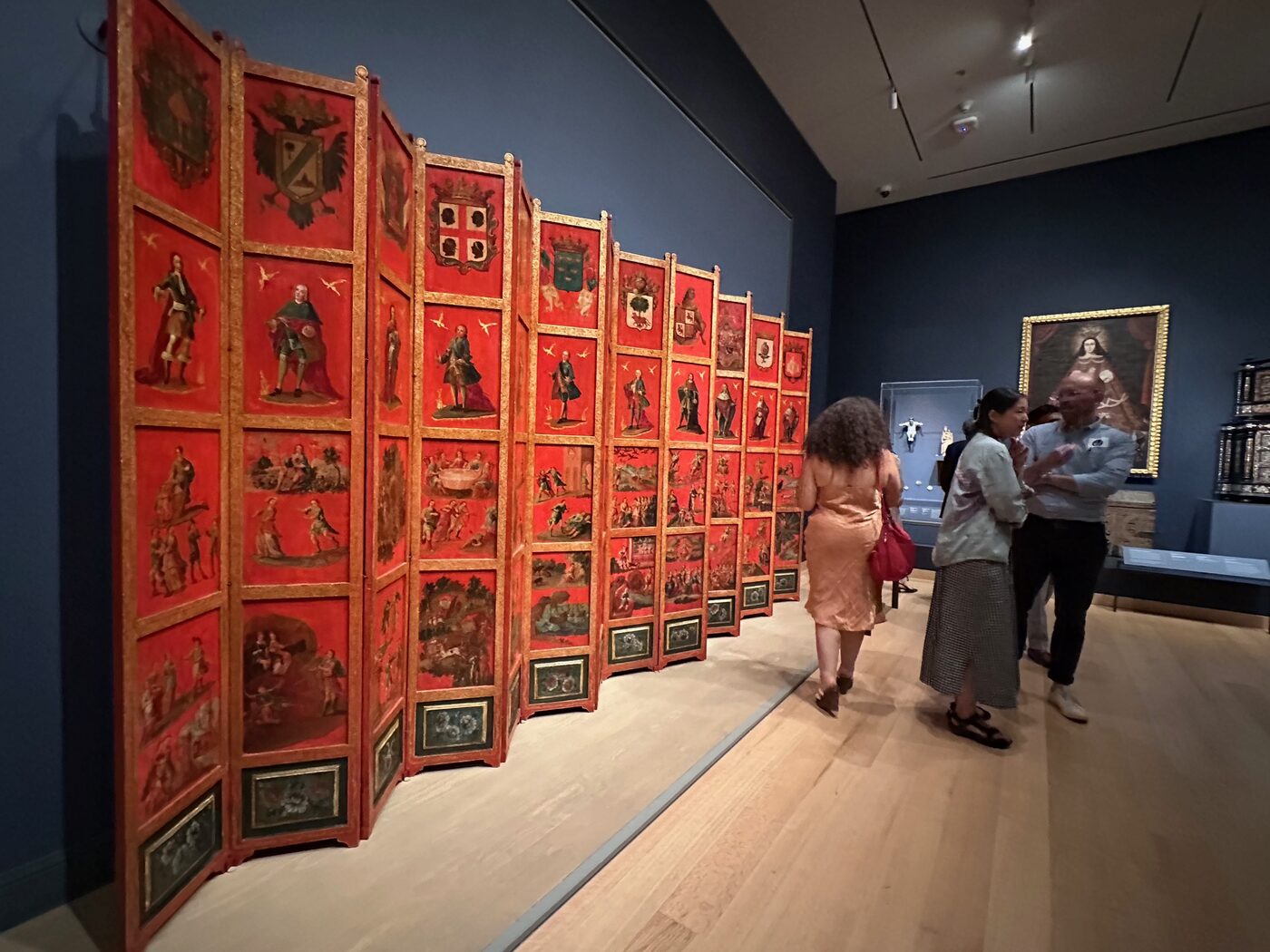 A gallery lined with red-framed works on red walls at the Museum of Fine Arts, Boston.