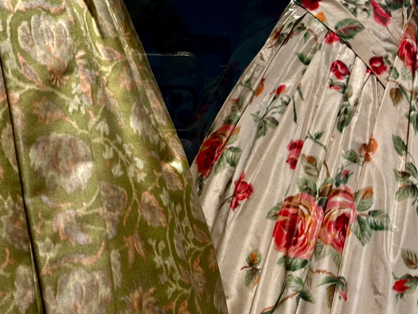 Detail of a rose-print silk dress beside a green damask weave at the MFA's Art in Bloom.