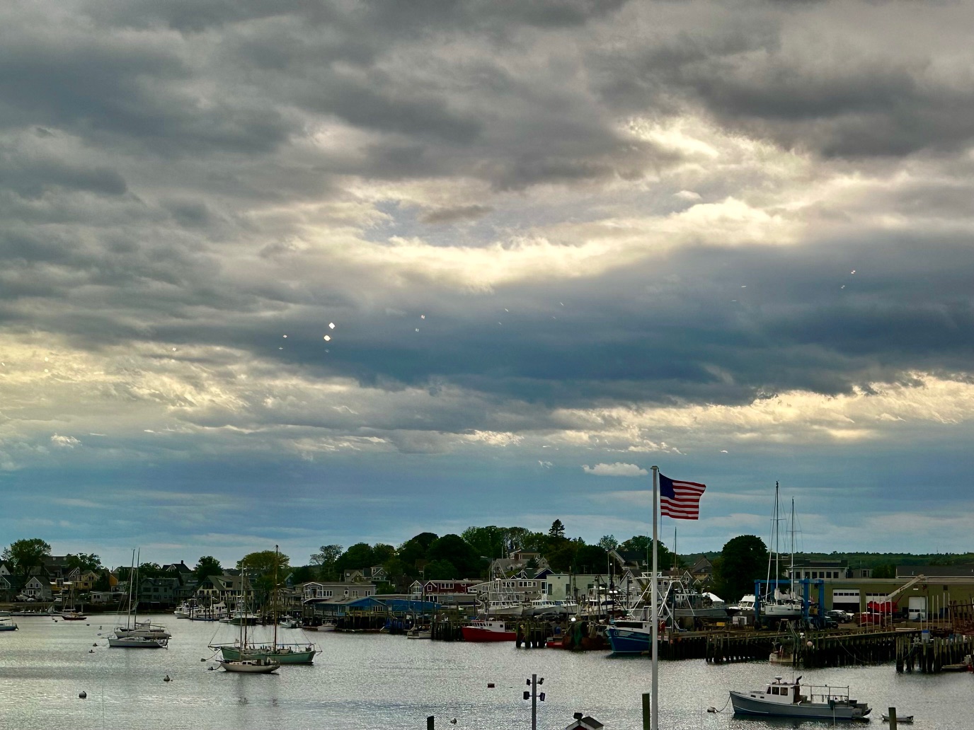 Gloucester's working waterfront and moored boats under a dramatic cloudy sky, near the North Shore Arts Association.